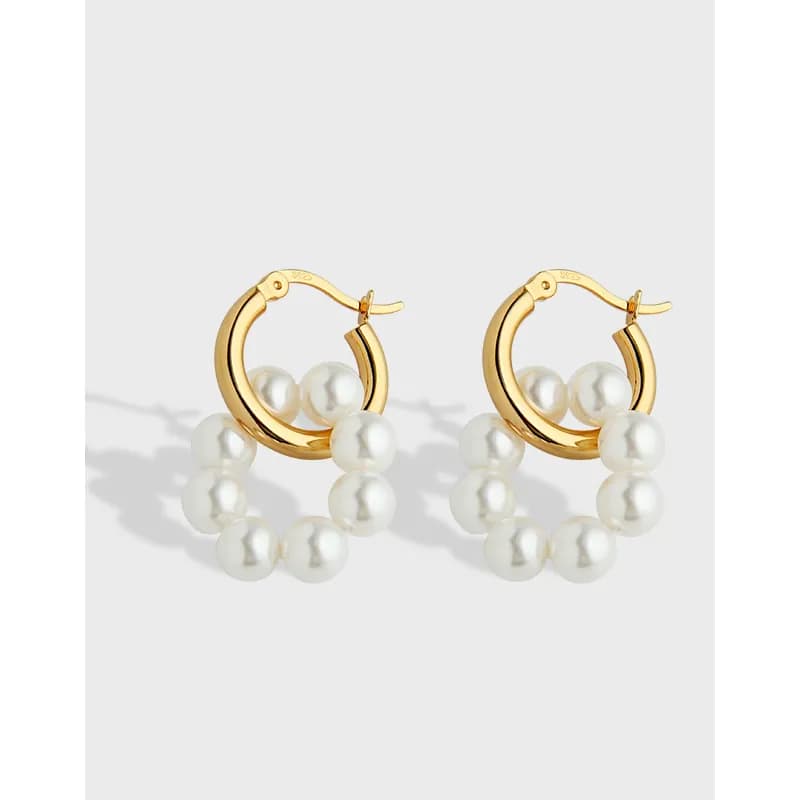 Polished gold-tone hoop earrings with a pearl strand along the bottom half