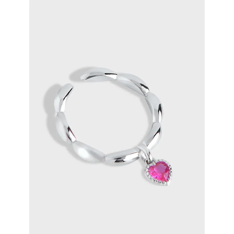 Polished sterling silver ring with chunky curved links and a pink heart charm dangling from one side.
