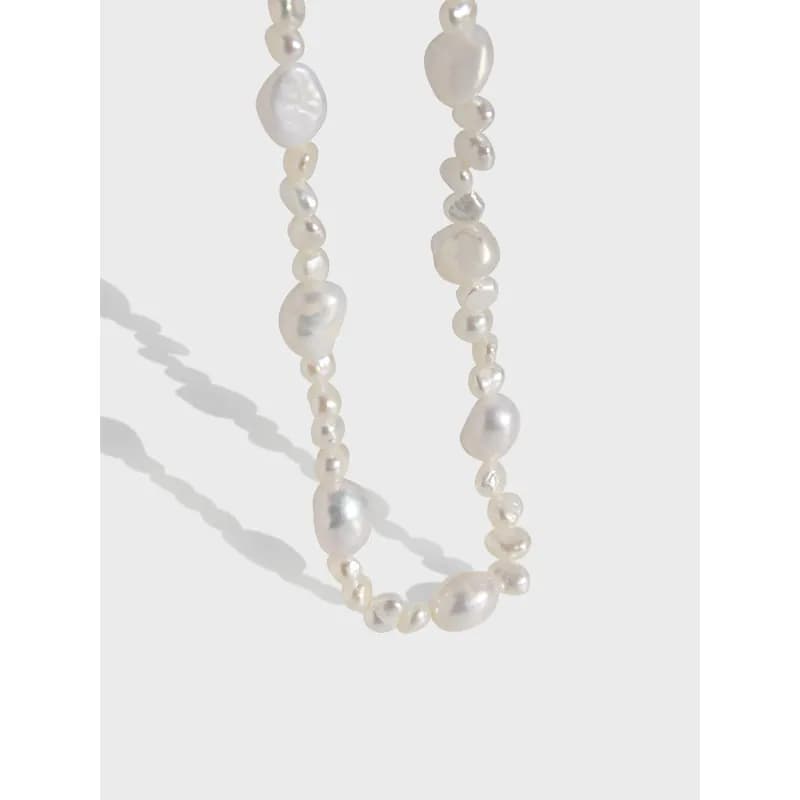 Close-up of a freshwater pearl necklace with irregular baroque pearls on a white background.