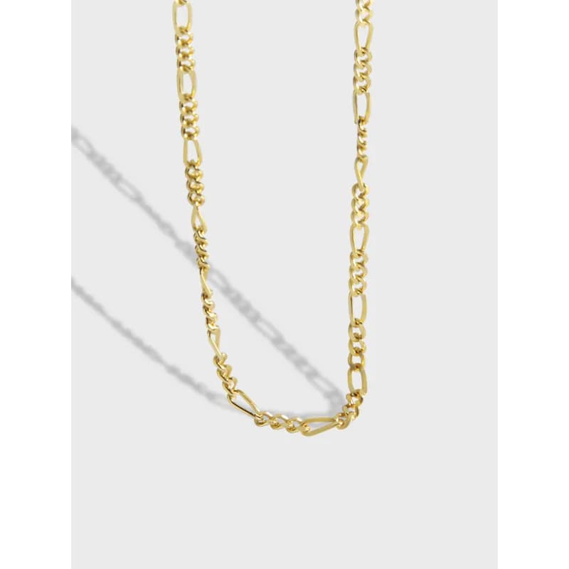 Polished sterling silver necklace with a mixed-link Figaro chain hanging against a light background.