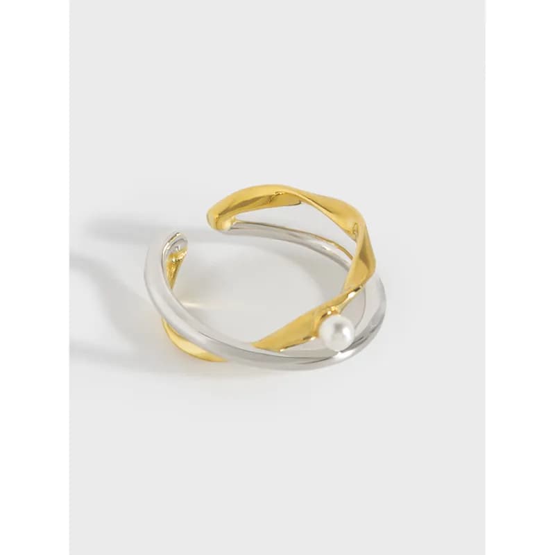 Polished two-tone intertwined silver and gold ring with a small pearl accent on the outer curve.