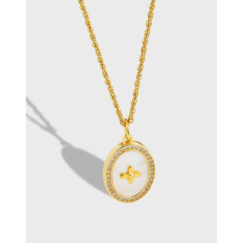 Round pendant with crystal-studded edge on a delicate chain