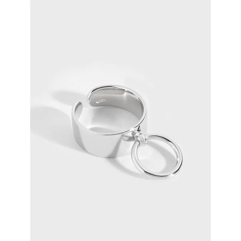 Polished silver wide-band ring with a circular hoop charm attached