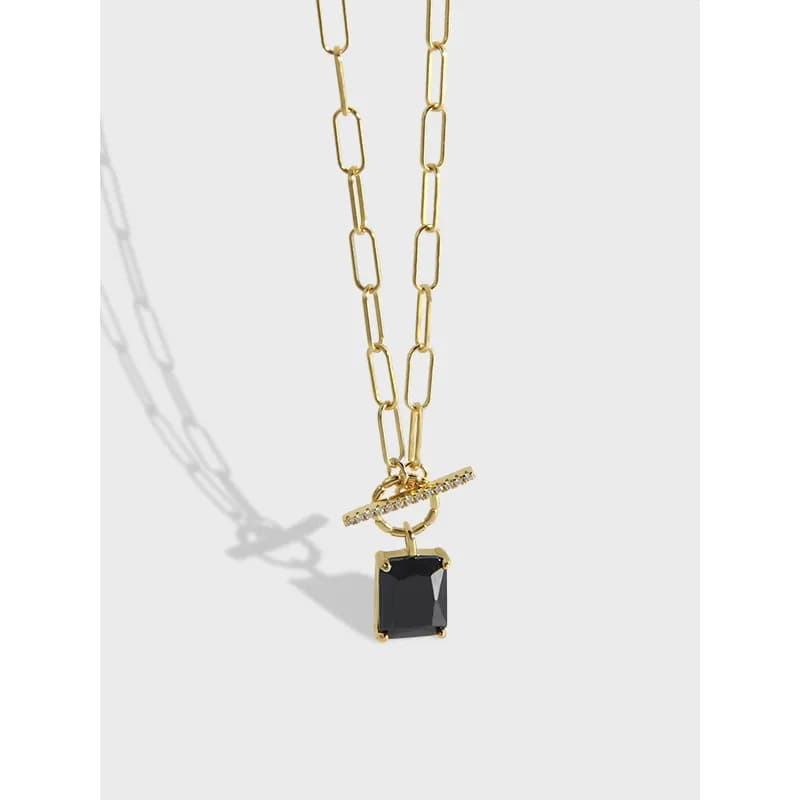 Polished chain necklace with large rectangular links and a square black gemstone pendant
