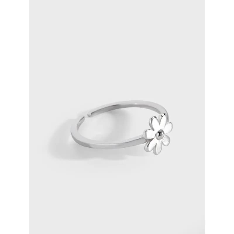 Polished sterling silver ring with a small daisy flower accent at the band