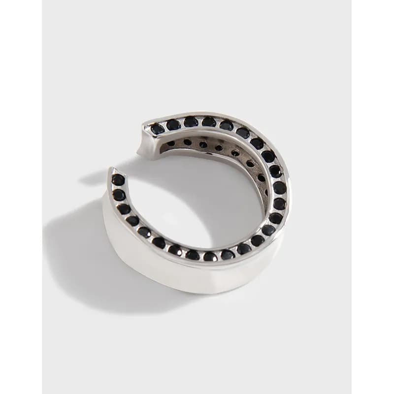 Polished sterling silver open C-shaped ring with black stones along the outer curve.
