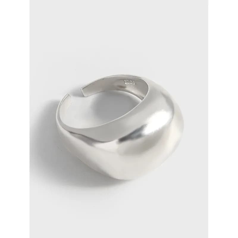 Polished sterling silver chunky curved ring with an open gap on a light background.