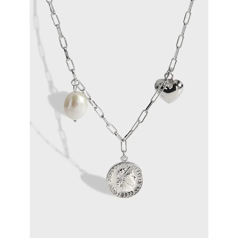 Sterling silver necklace with a pearl charm and coin pendant hanging from a chain