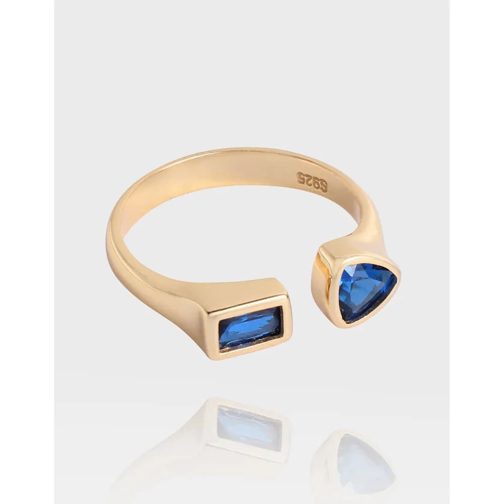 Open-ended sterling silver ring with blue rectangular and triangular stones in bezel settings.