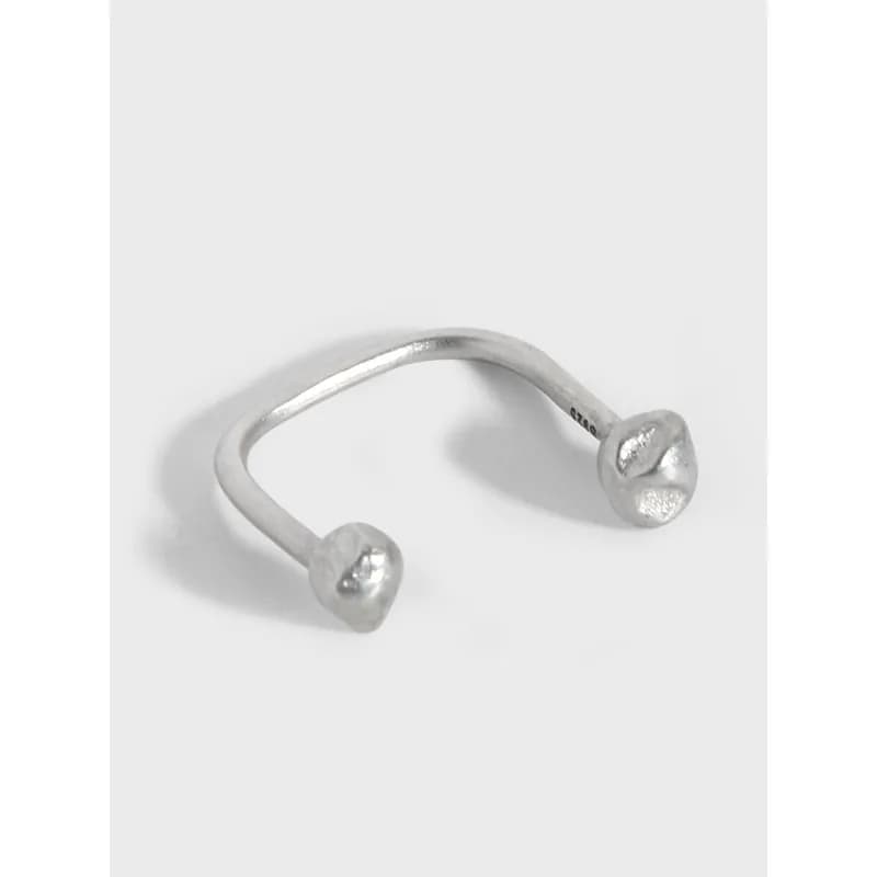 Polished sterling silver open ring with two rounded ends, one featuring a small stone.