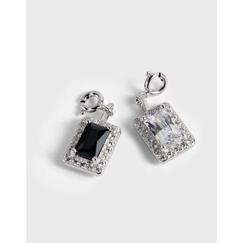 Polished sterling silver square halo pendants with pavé edge and central stones on a white background.