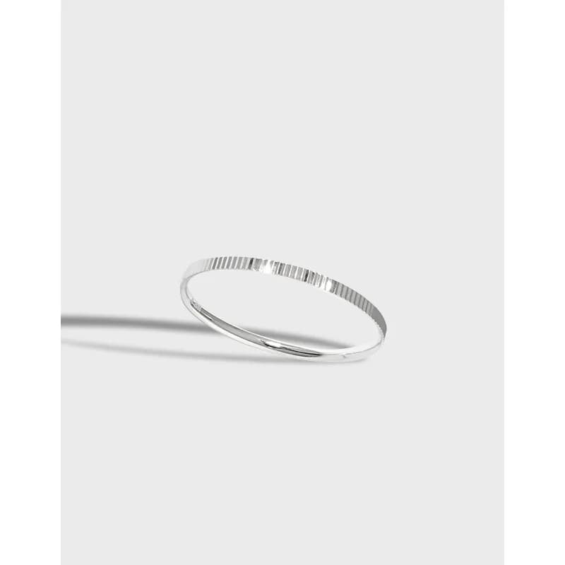 Slender sterling silver ring with a fine vertical ribbed texture on a light background.