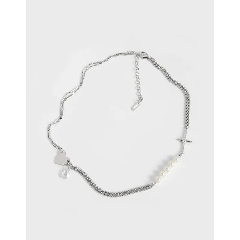 Sterling silver necklace with heart and star charms, crystal drop, pearls, and mixed chains on a white background.