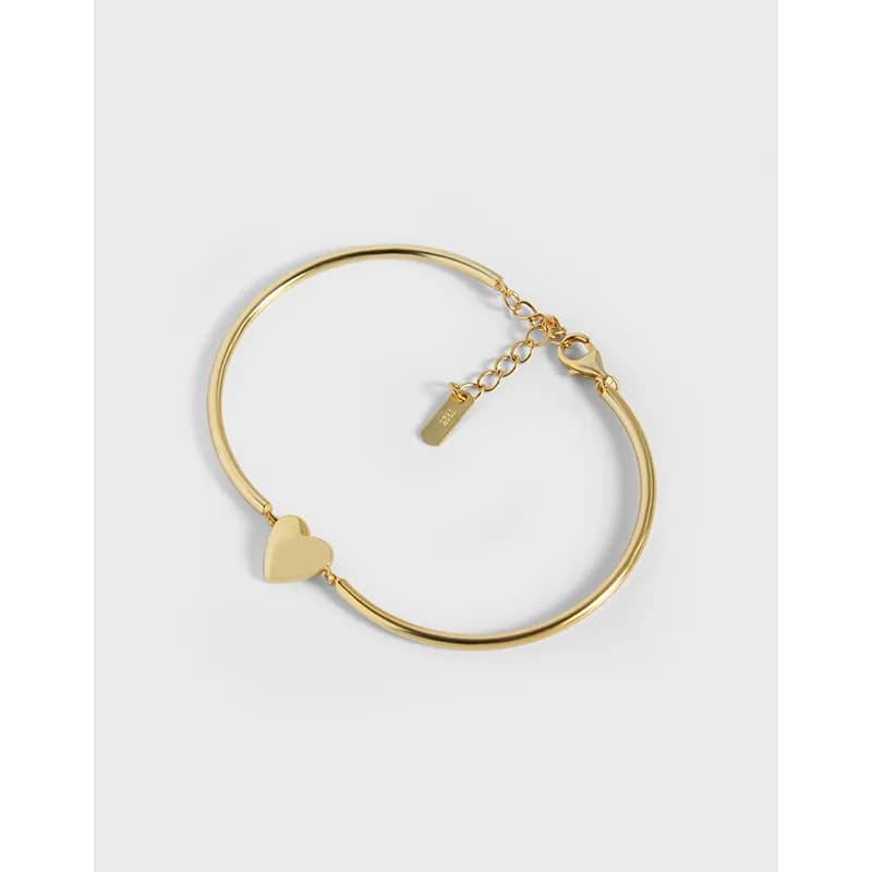 Polished sterling silver bracelet with a small heart charm and adjustable chain clasp.