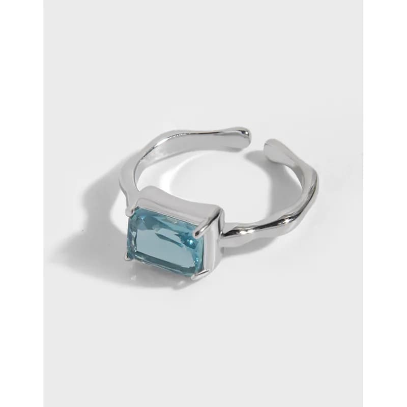 Polished sterling silver ring with a rectangular blue stone in a minimalist open-band setting.