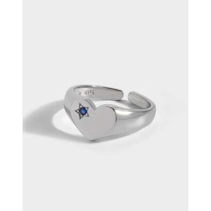 Polished sterling silver ring featuring an open heart design with a small blue star inlay on the centerpiece.