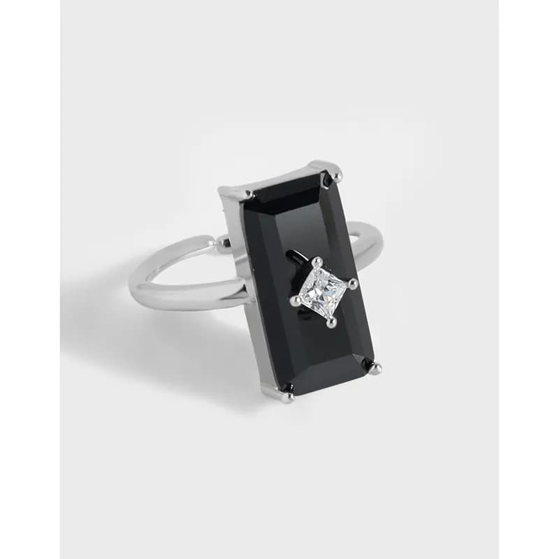 Sterling silver ring with a tall rectangular black gemstone and a small clear center accent