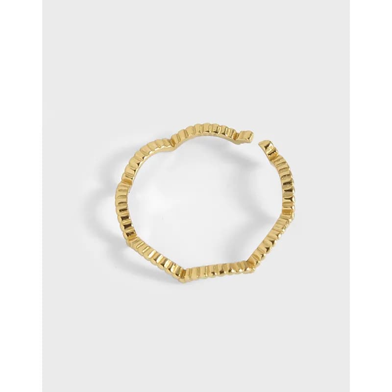 Polished faceted bead ring with a segmented band on a light background.