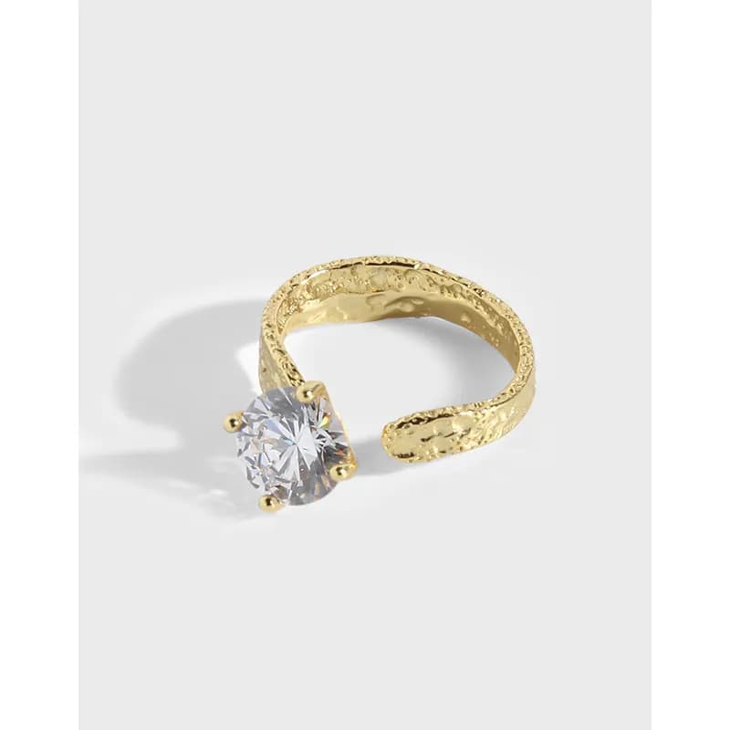 Open-ended textured sterling silver ring with a single round diamond-like stone in a four-prong setting.