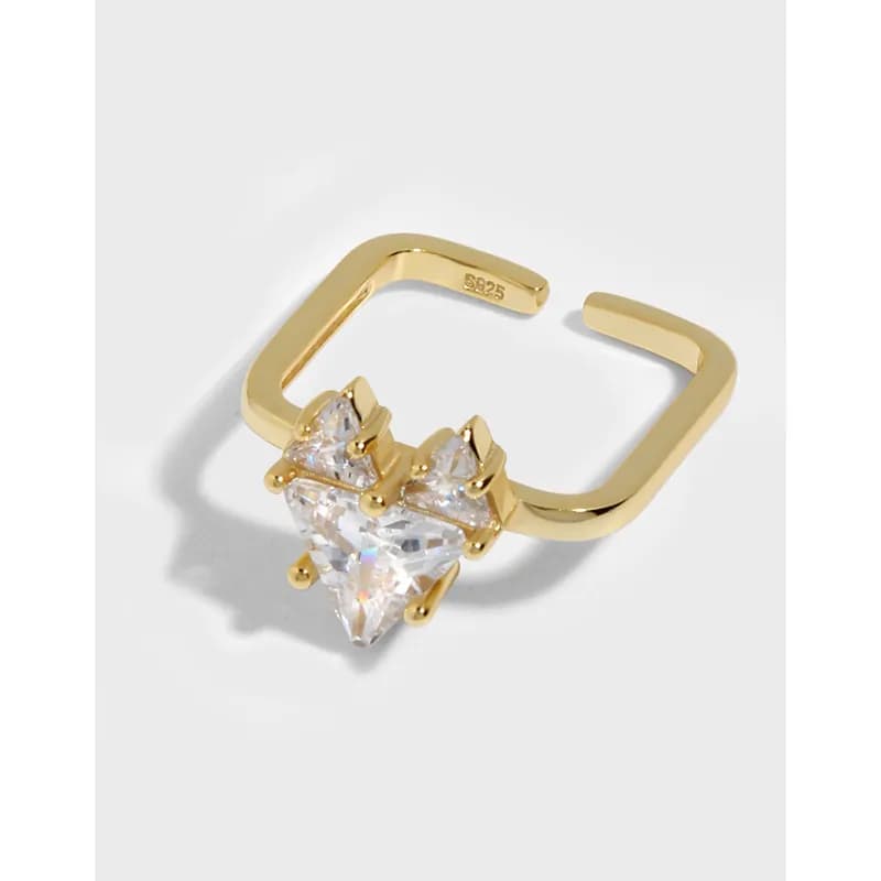 Open geometric ring in polished silver with a tall clear crystal centerpiece held by angular prongs.