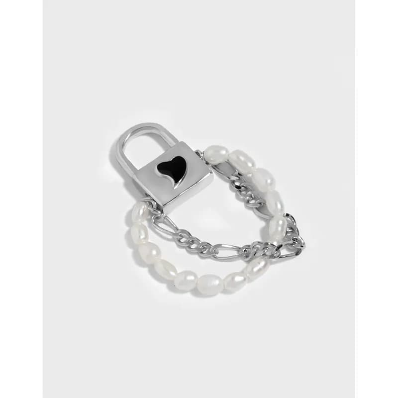 Polished sterling silver ring with a heart-cut padlock and pearl-chain wrap on a white background.