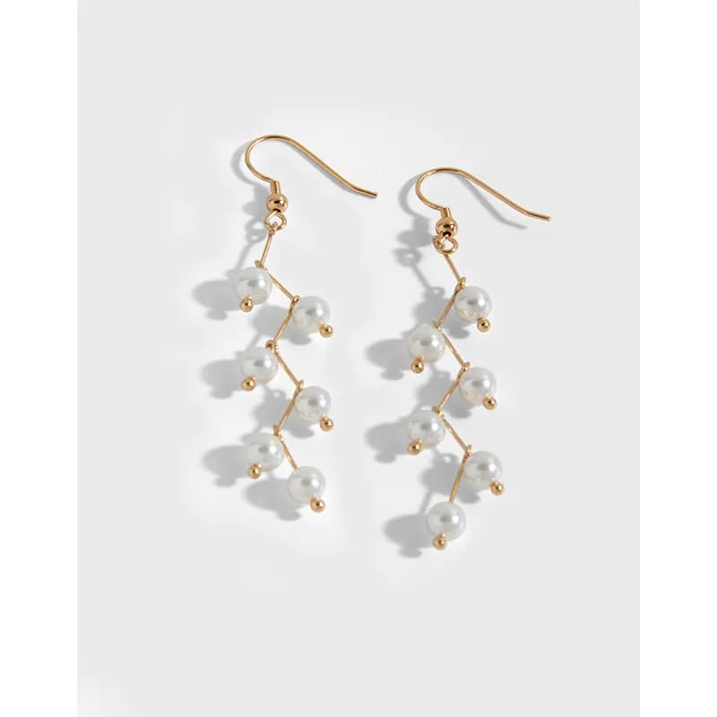 Delicate gold-tone branching earrings with multiple white pearls along a zigzag chain