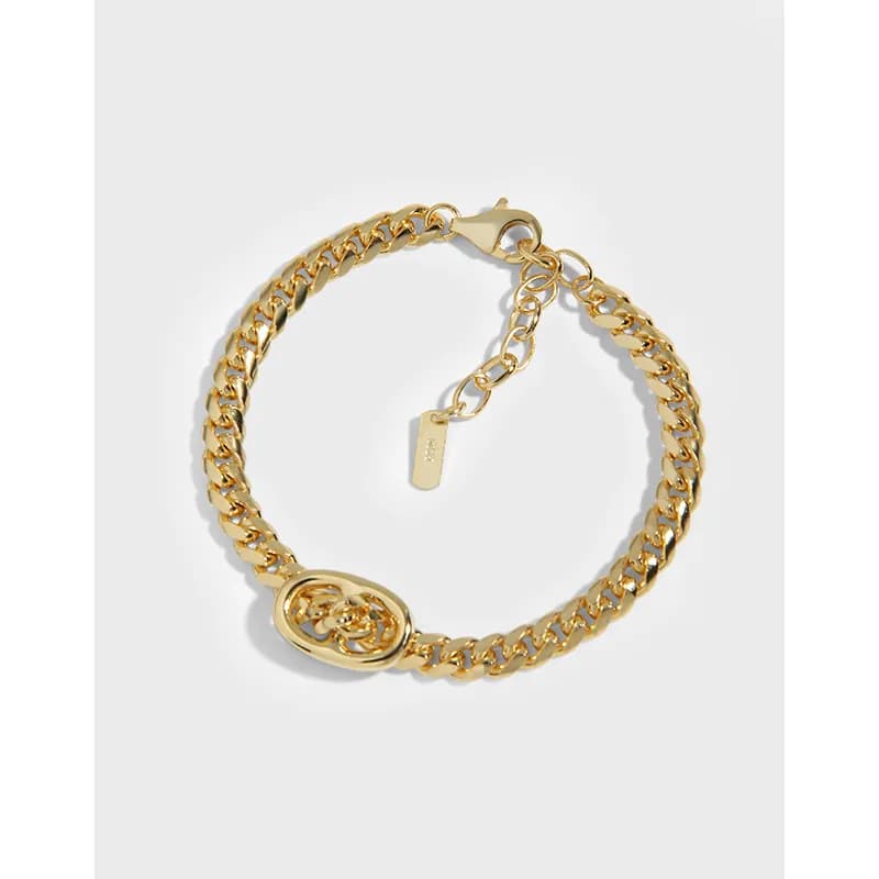 Polished gold-tone oval knot bracelet with a curb chain and extender chain on a white background.