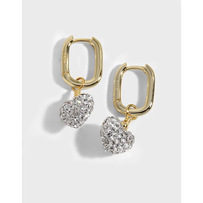 Polished sterling silver hoop earrings with dangling crystal heart charms.
