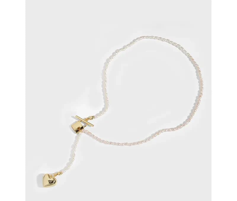 Delicate sterling silver bead necklace with a small gold heart charm