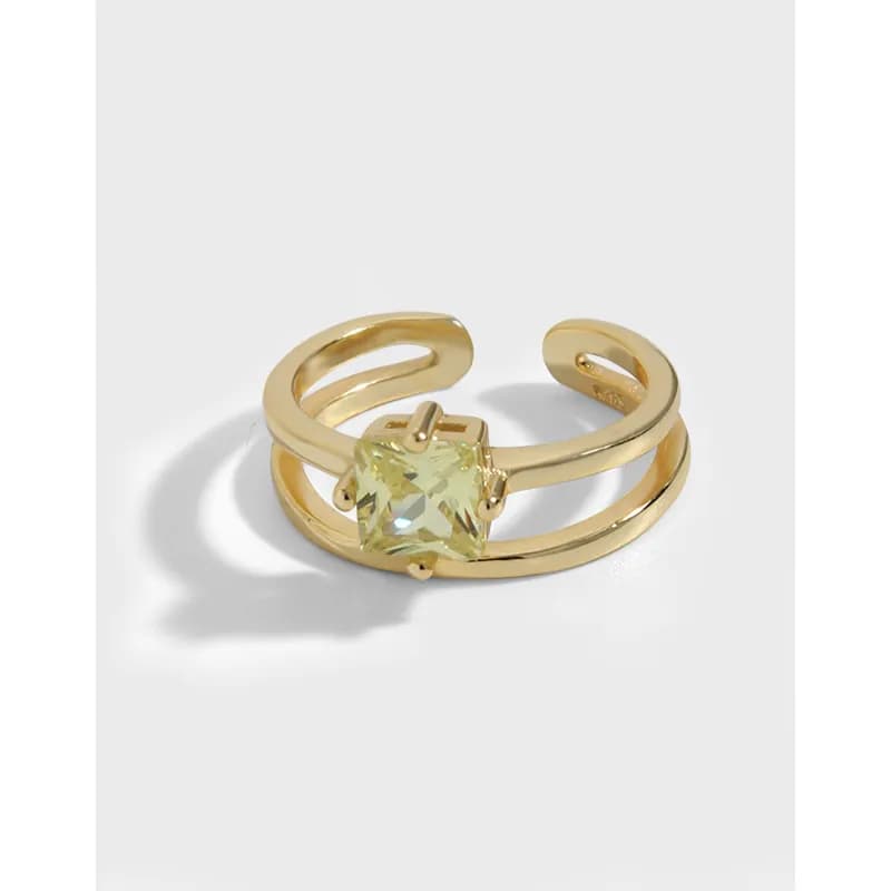 Polished two-band ring with a square pale gemstone held by four prongs.