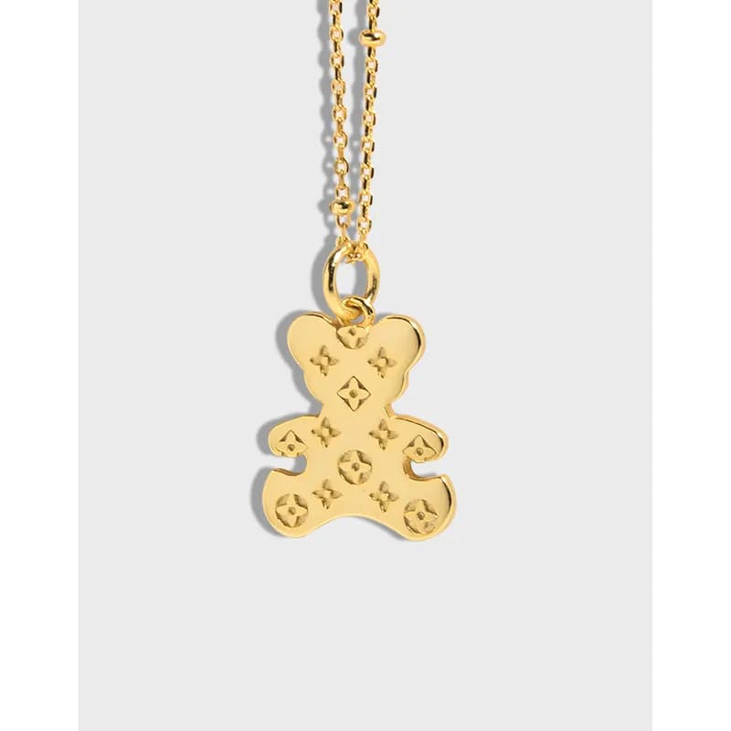 Gold-tone bear pendant with star-shaped cutouts on a delicate chain