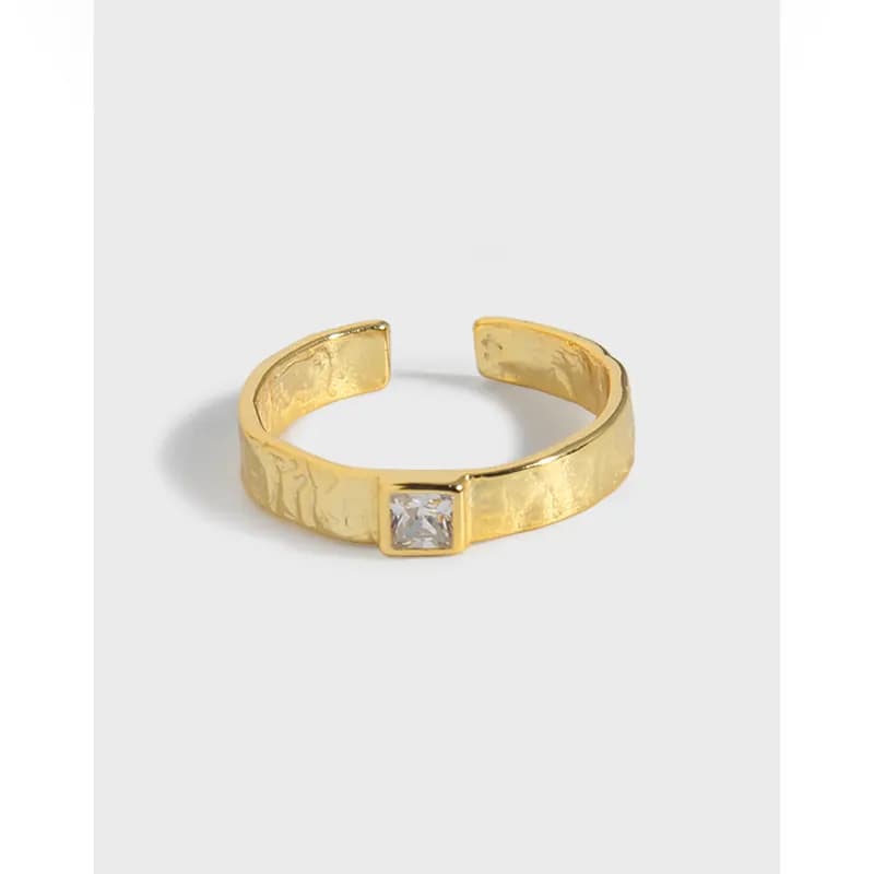 Polished sterling silver hammered ring with a square bezel-set stone on an open band.