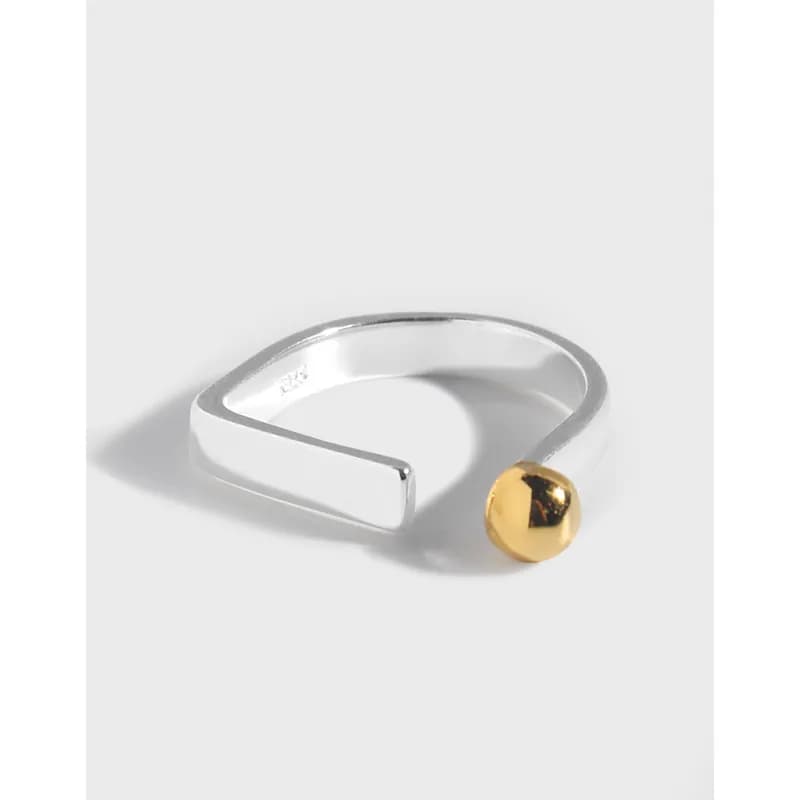 Polished sterling silver open-band ring with a gold ball accent at the end.