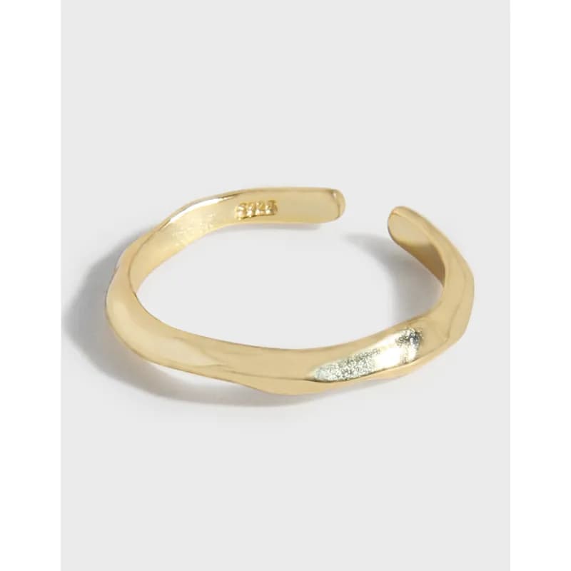 Open-ended hammered band ring in polished sterling silver with a warm gold tone.