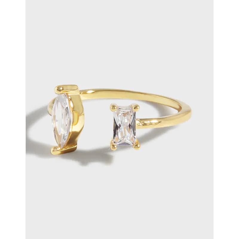 Open-ended two-stone ring with marquise and emerald-cut stones on a polished band.