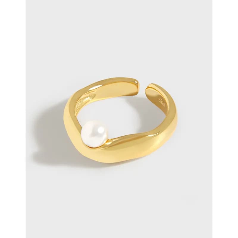 Open curved ring in gold-tone metal with a single white pearl on the band.