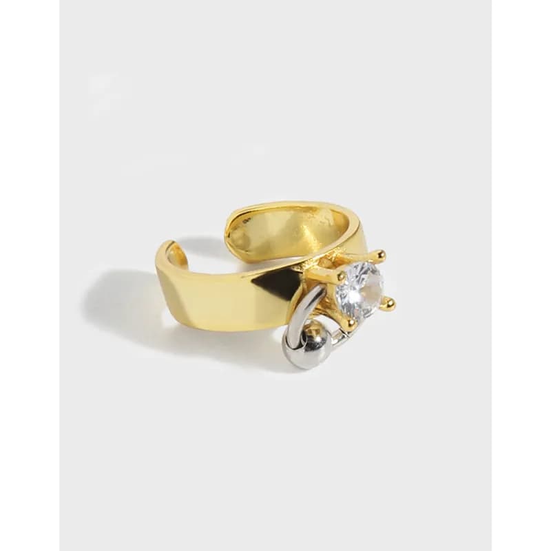 Close-up view of a two-tone solitaire earring with a gold-toned band and clear crystal pressed in front