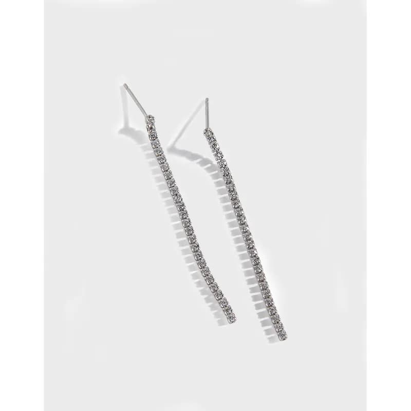 A pair of slender, pavé-set bar earrings in polished sterling silver hanging from posts.
