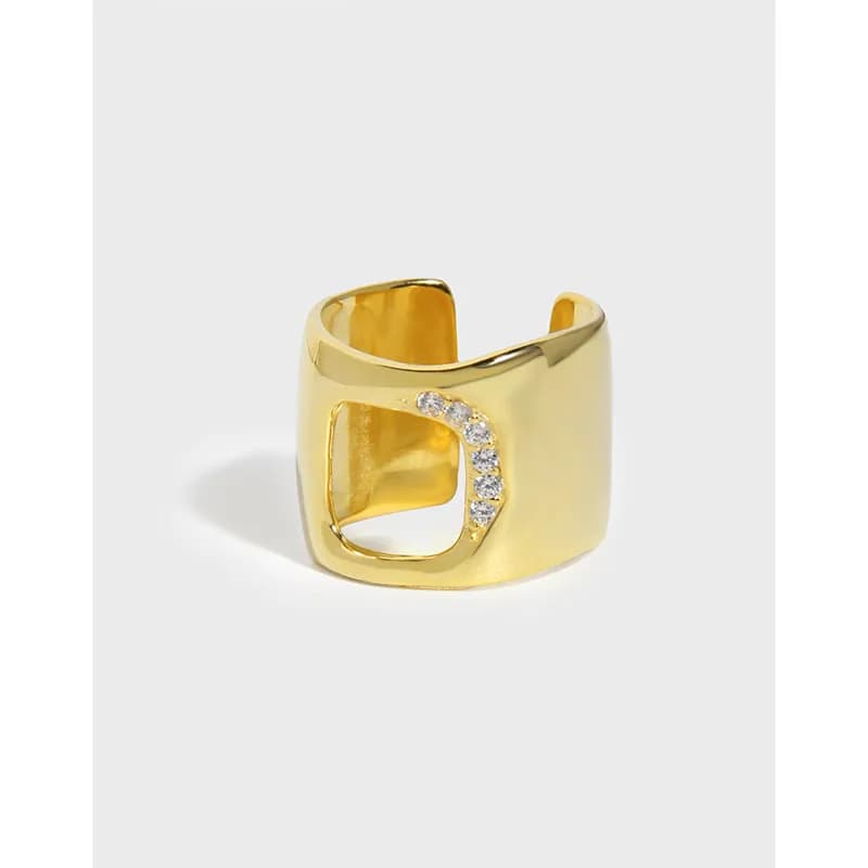 Polished gold-tone ring with an open square cutout and diamond-accent along one edge.