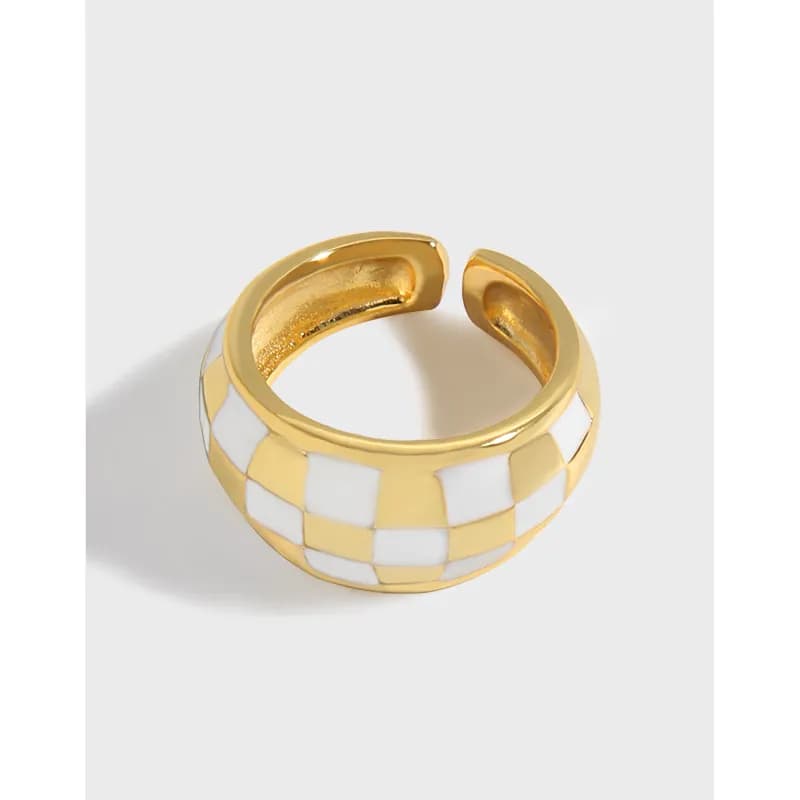 Wide polished ring with a white and gold checkerboard pattern on a white background.
