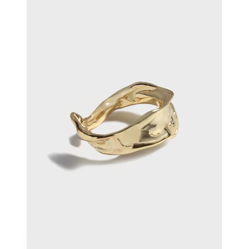 Polished sterling silver ring with an organic, wave-like sculptural form on a light background.