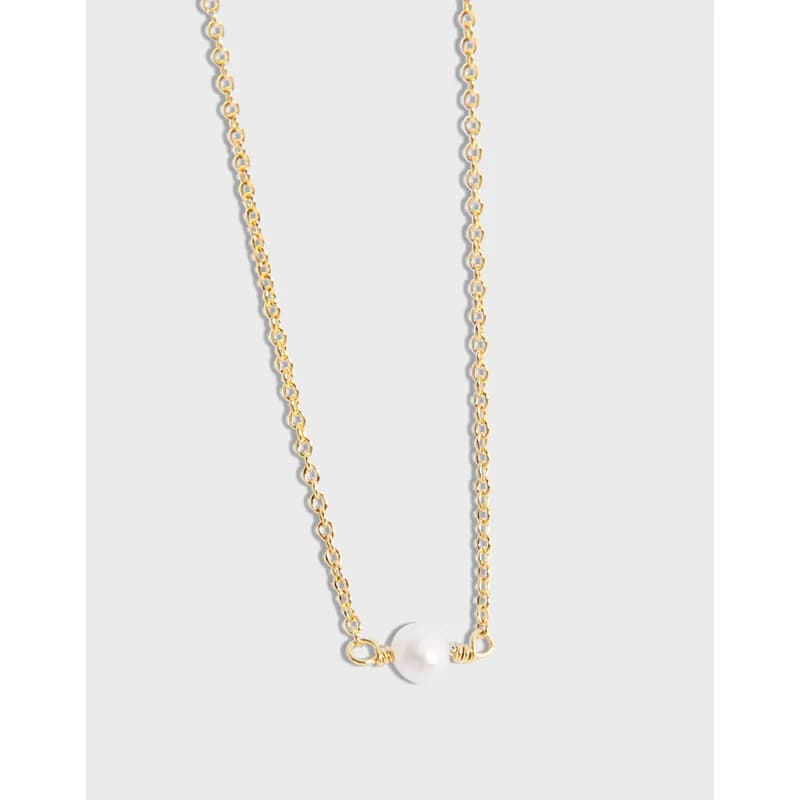 Delicate pearl pendant necklace on a fine chain.