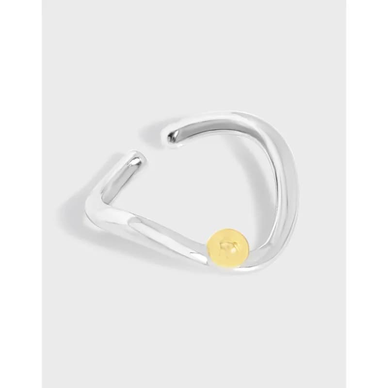 Polished sterling silver open curve ring with a small gold bead accent on one end.