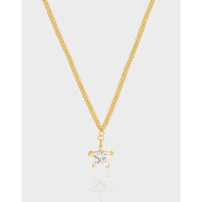 Delicate star pendant on a polished chain shown against a light background.
