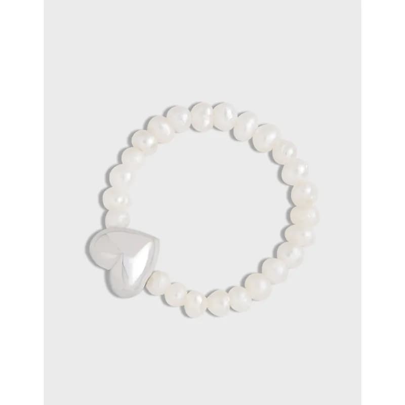 A sterling silver beaded ring with a heart-shaped charm on a light background.