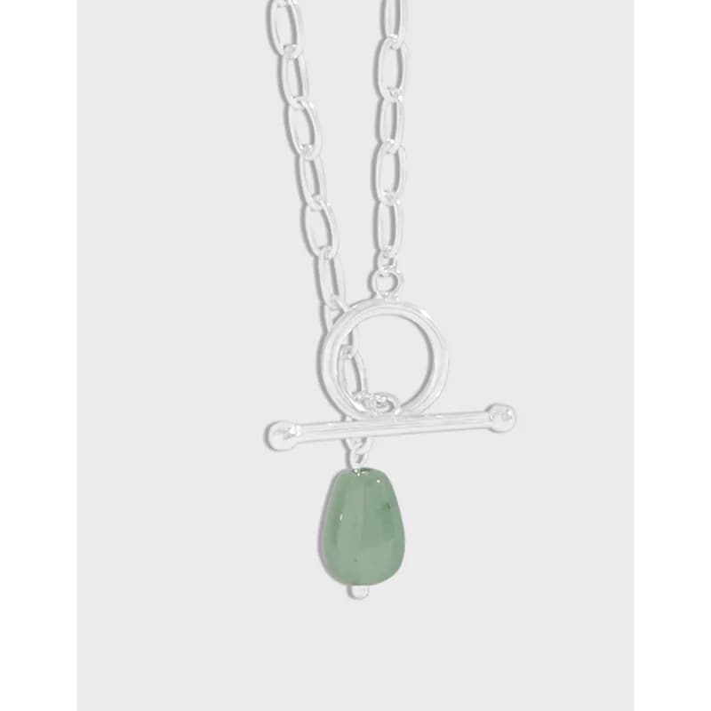 Polished sterling silver necklace featuring a circle ring, horizontal bar pendant, and a green teardrop gemstone.