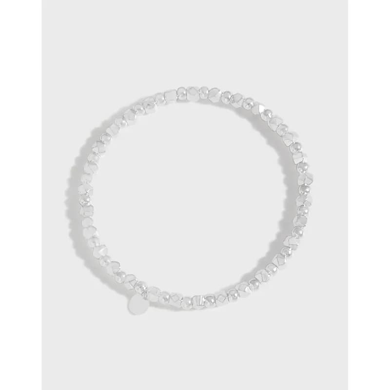 Sterling silver beaded bracelet with a small round disc charm on a white background.