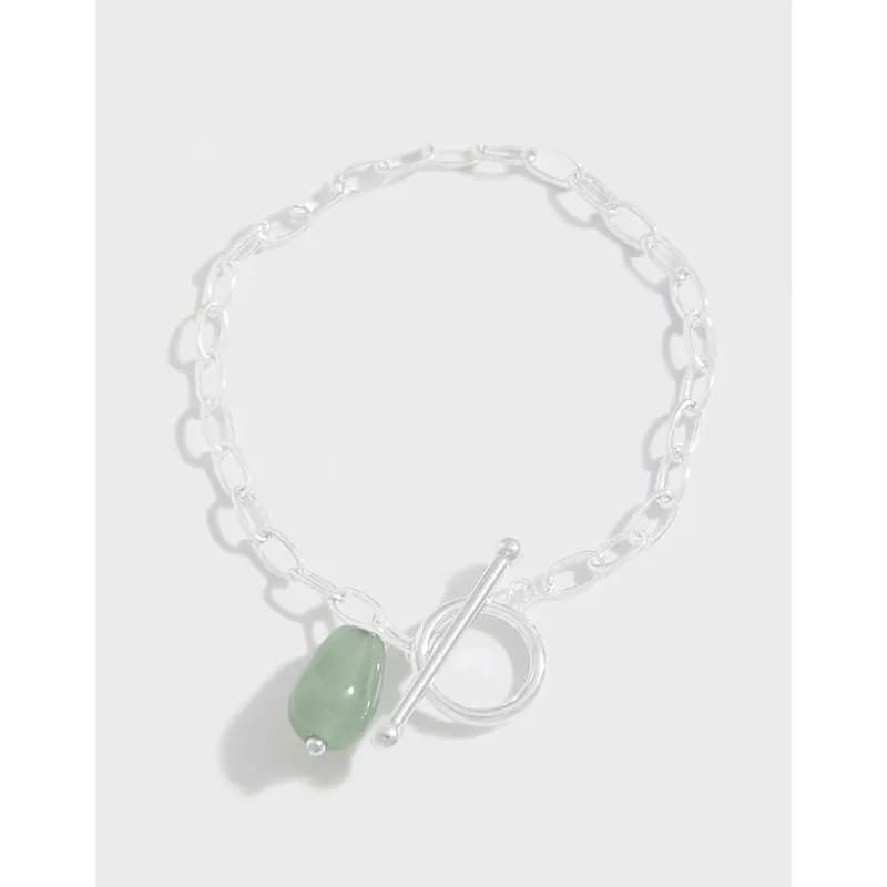 Polished sterling silver bracelet with a green teardrop gemstone charm and toggle clasp