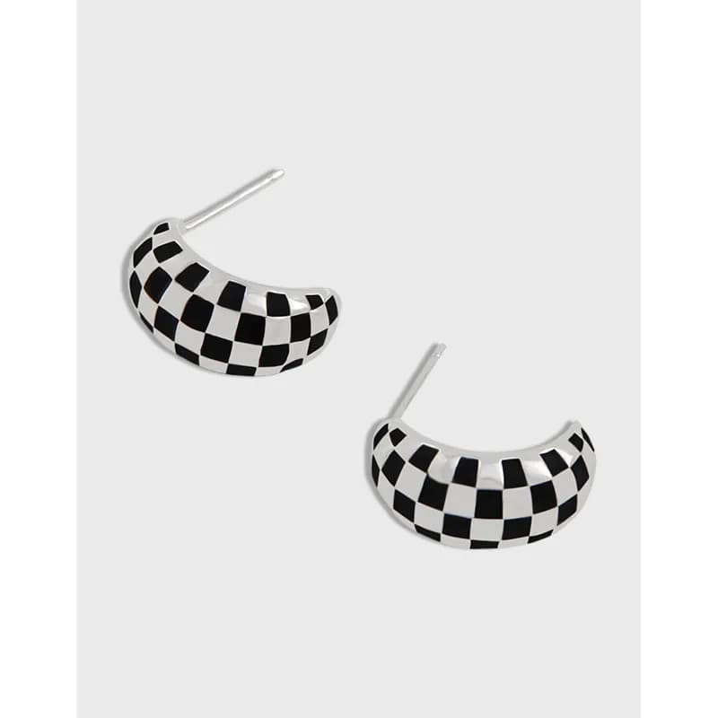 Polished sterling silver crescent earrings with a black and white checkerboard pattern.