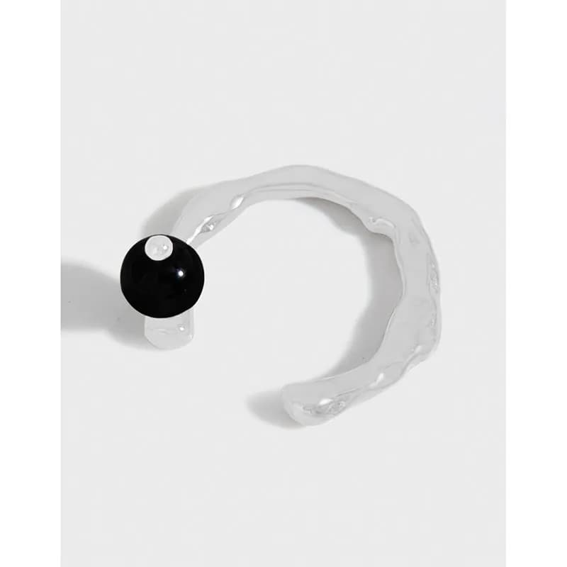 Polished sterling silver open ring with a textured band and a single black bead at the end.